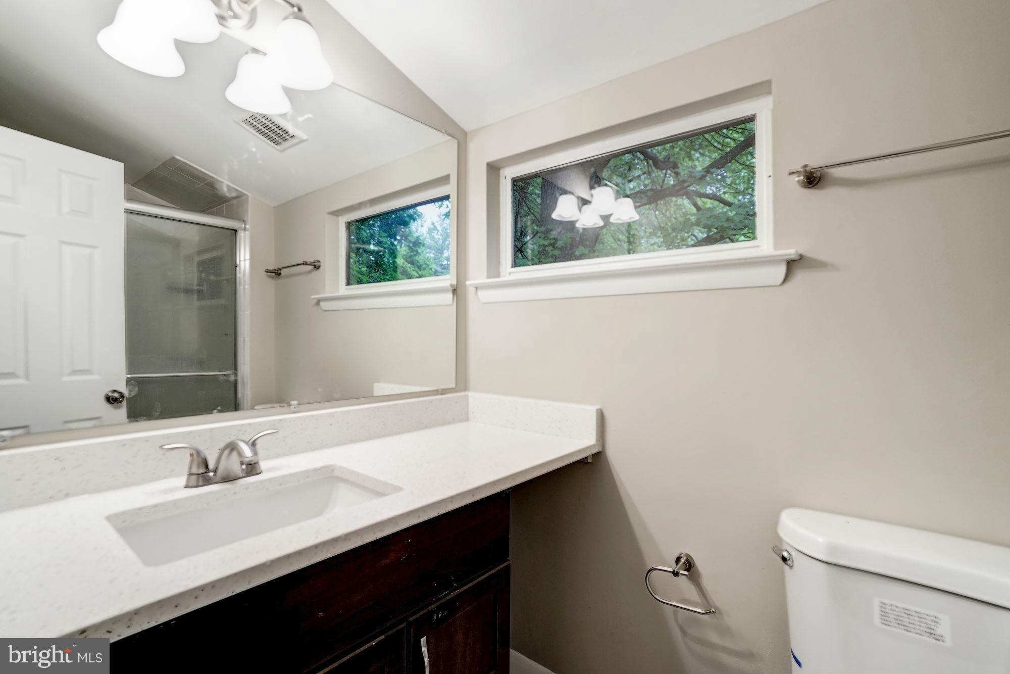 11704 Decade Court Reston, VA 20191 - Photo 20 of 30 a bathroom with a sink a toilet a mirror and a window