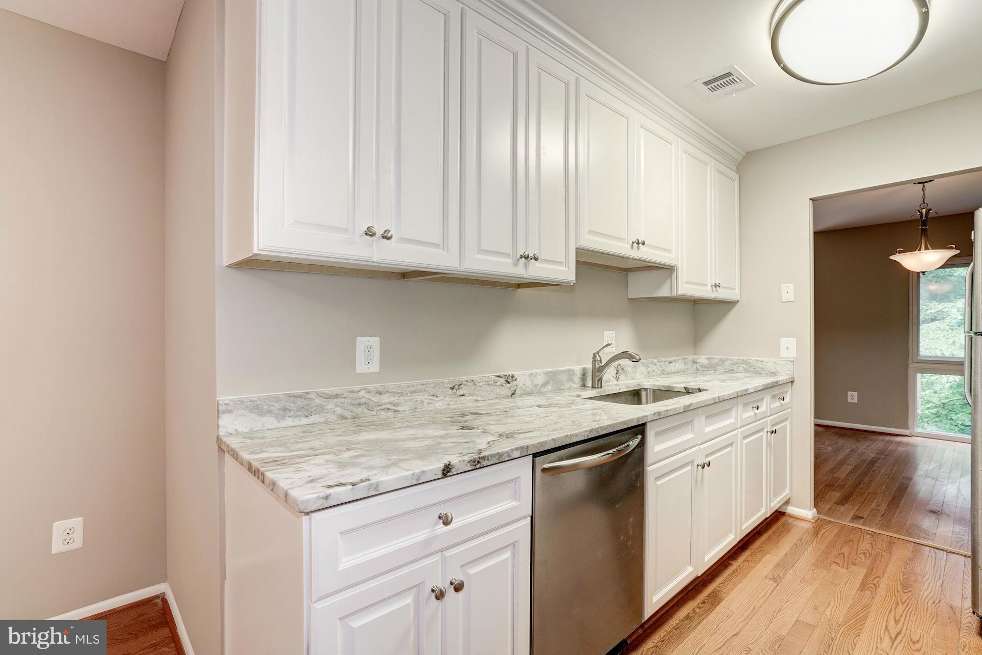 11704 Decade Court Reston, VA 20191 - Photo 6 of 30 a kitchen with granite countertop white cabinets and a sink