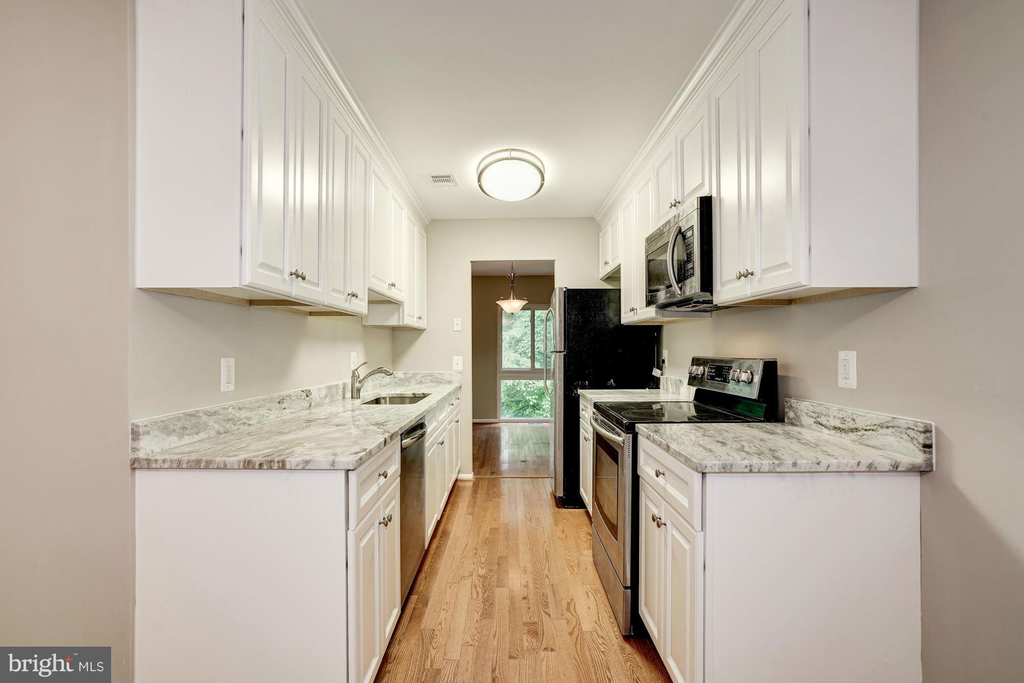 11704 Decade Court Reston, VA 20191 - Photo 8 of 30 a kitchen with stainless steel appliances granite countertop a stove a sink and a microwave