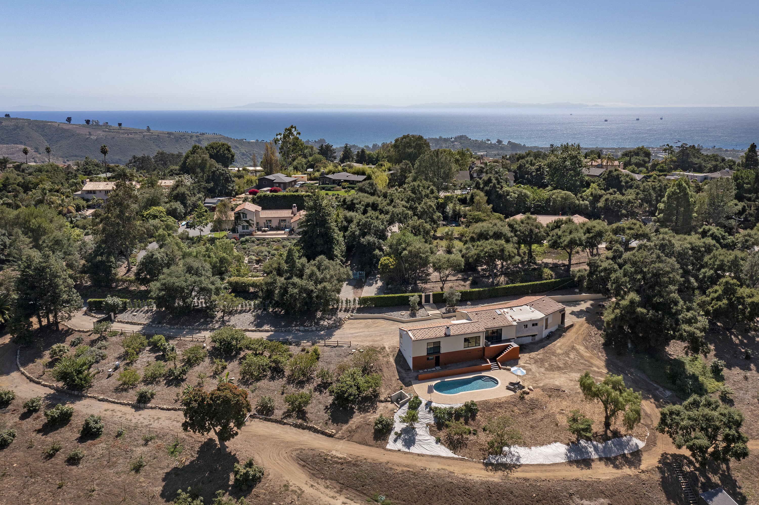 an aerial view of a house with a lot of trees & cars