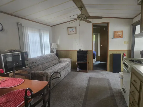 a living room with furniture a flat screen tv and gym equipment