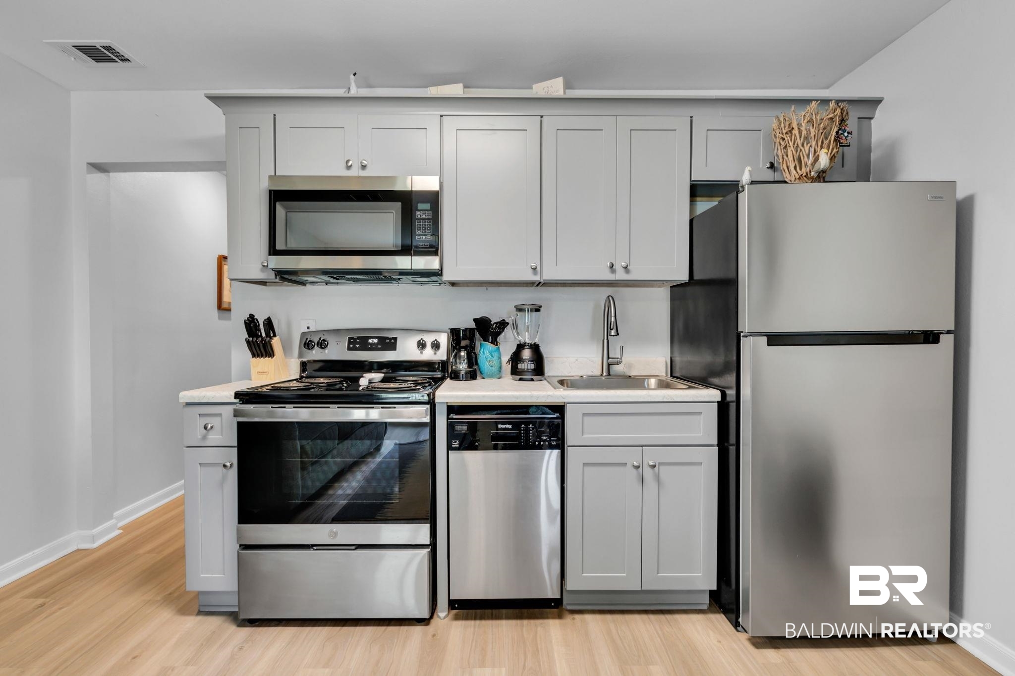 400 Plantation Road, Unit 4115 Gulf Shores, AL 36542 - Photo 12 of 48 Kitchen with gray cabinetry, light hardwood / wood-style flooring, sink, and stainless steel appliances