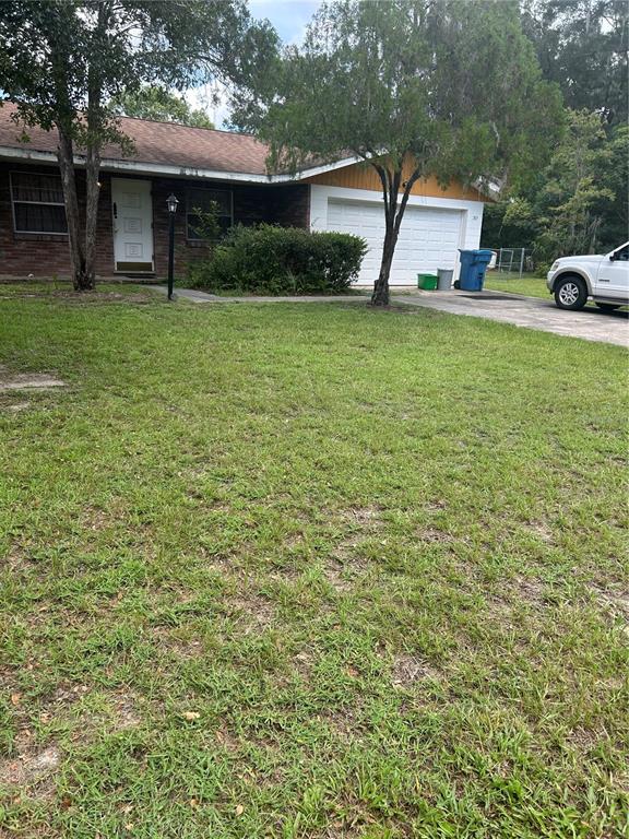 a front view of a house with a yard and trees