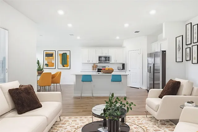 a living room with furniture and kitchen view