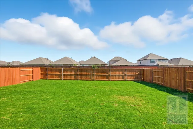 a view of a terrace with a garden and wooden fence