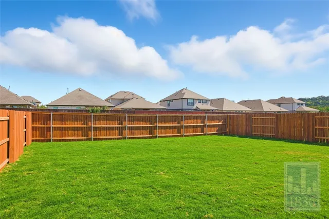 a view of yard with swimming pool and brick wall