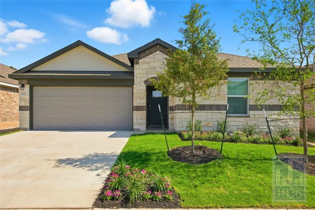 a front view of a house with a garden and yard