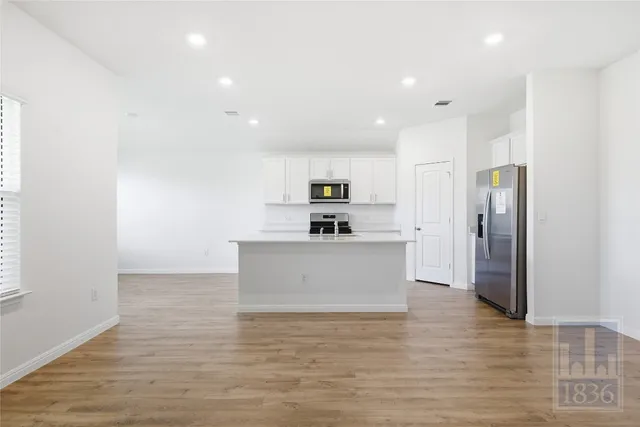 a view of kitchen with stainless steel appliances granite countertop a stove a sink and a refrigerator