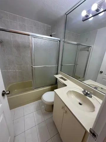 a bathroom with a sink mirror toilet and shower