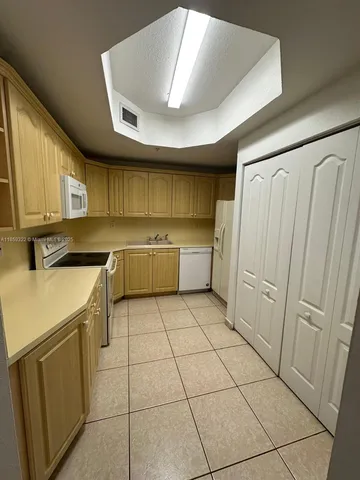 a kitchen with a sink a refrigerator and cabinets