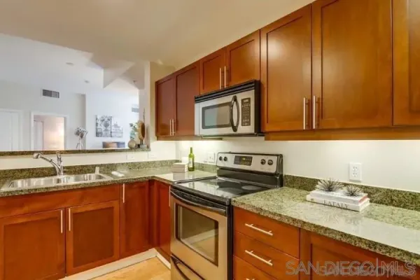 a kitchen with stainless steel appliances granite countertop a sink stove and cabinets