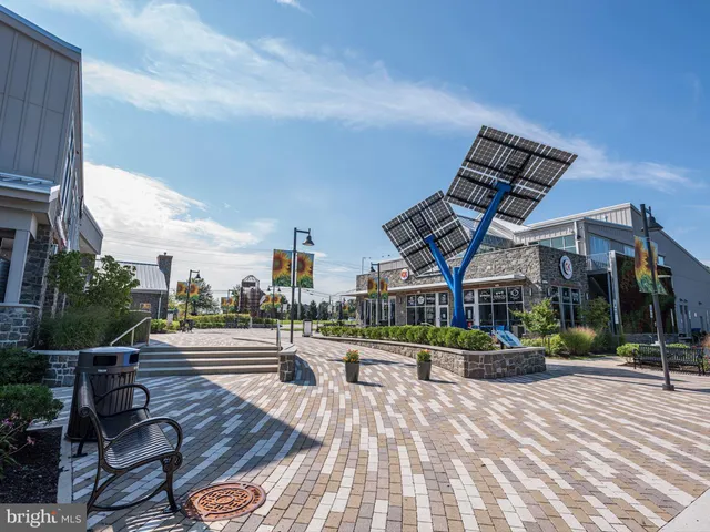 a view of a patio with table and chairs a barbeque with potted plants and a large window