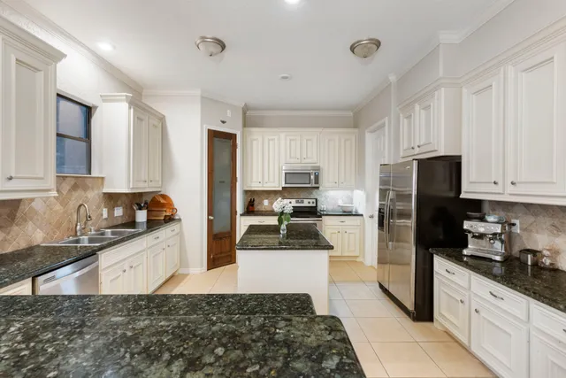 a kitchen with granite countertop a refrigerator and a sink