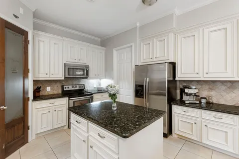 a kitchen with white cabinets and stainless steel appliances