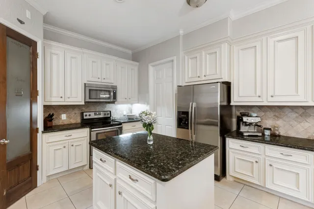 a kitchen with white cabinets and stainless steel appliances