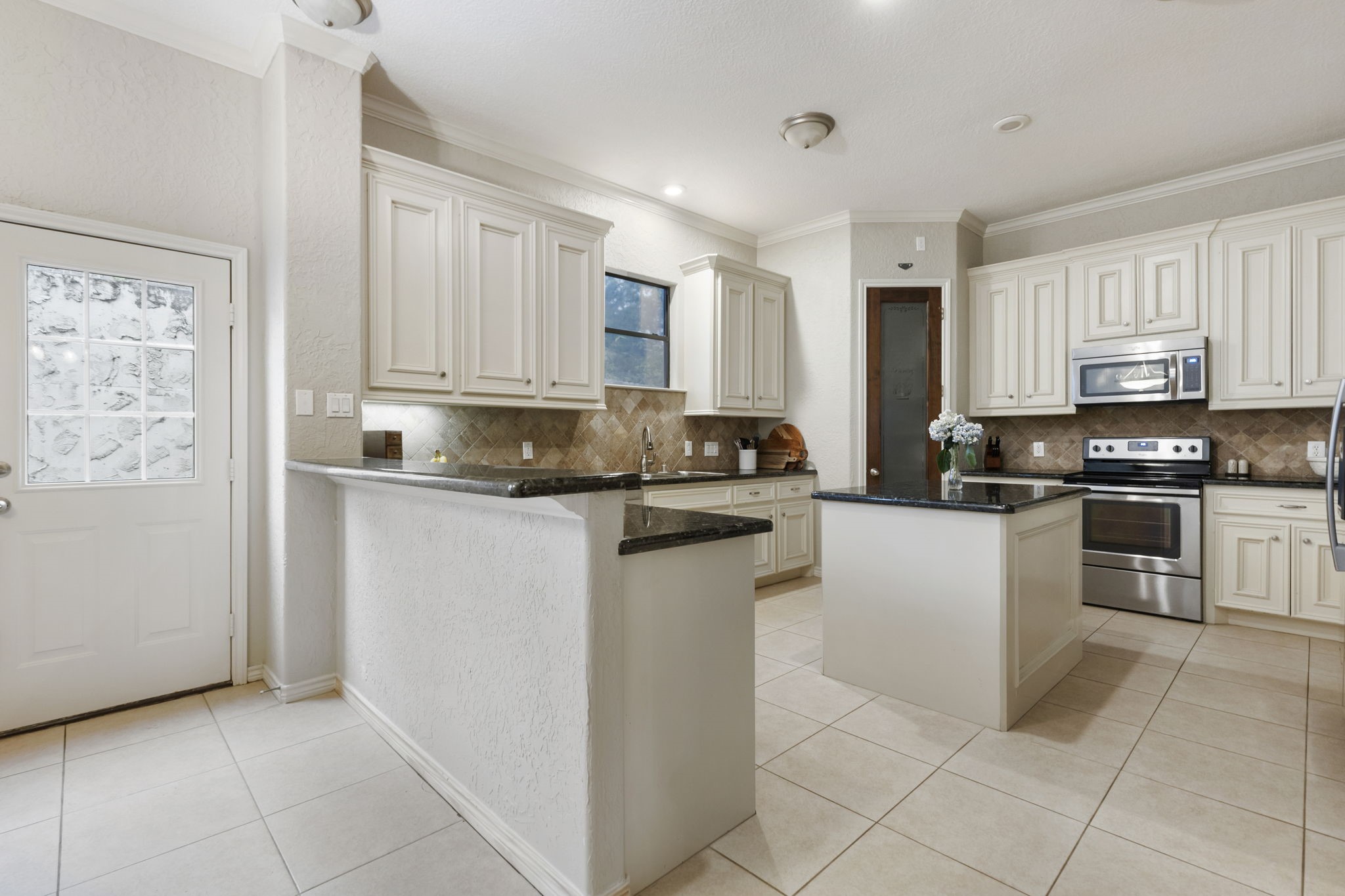1898 Longmire Road, Unit 8 Conroe, TX 77304 - Photo 10 of 26 a kitchen with stainless steel appliances granite countertop a stove a sink and a refrigerator