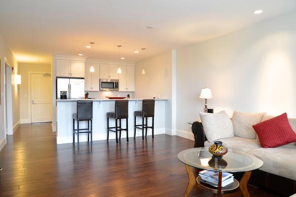 116-128 Rantoul Street, Unit 507 Beverly, MA 01915 - Photo 1 of 13 a living room with furniture and wooden floor