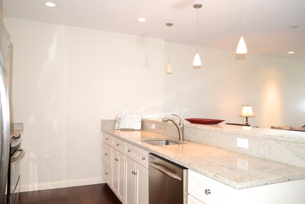 116-128 Rantoul Street, Unit 507 Beverly, MA 01915 - Photo 6 of 13 a bathroom with a granite countertop sink and a mirror