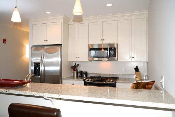 116-128 Rantoul Street, Unit 507 Beverly, MA 01915 - Photo 8 of 13 a kitchen with stainless steel appliances granite countertop a sink a stove and a refrigerator