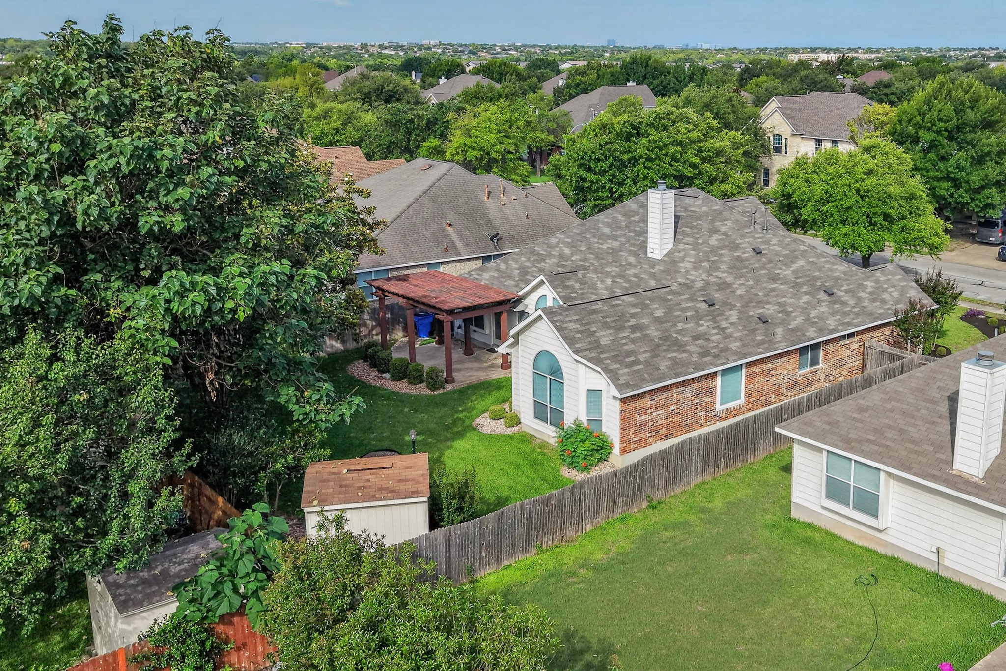 905 Victoria Ridge Drive Pflugerville, TX 78660 - Photo 29 of 32 An aerial perspective showcases a well-maintained backyard with a spacious patio, lush lawn, and charming pergola.