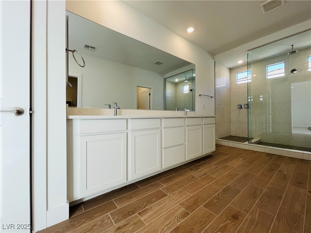 10237 Mystic Falls Drive Las Vegas, NV 89141 - Photo 12 of 23 Bathroom with a shower stall, double vanity, wood tiled floors, and recessed lighting