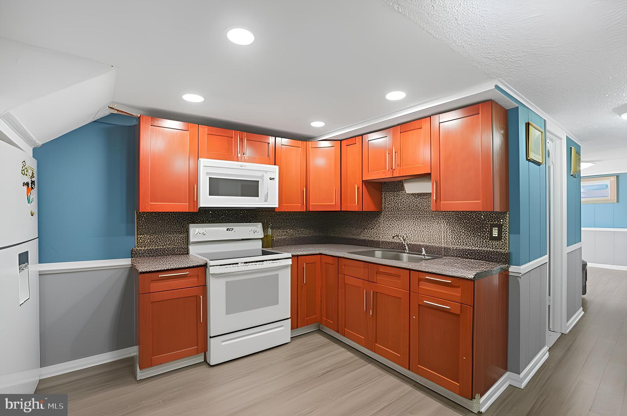 3414 Farthing Drive Silver Spring, MD 20906 - Photo 12 of 23 a kitchen with stainless steel appliances granite countertop wooden cabinets a sink and a large window