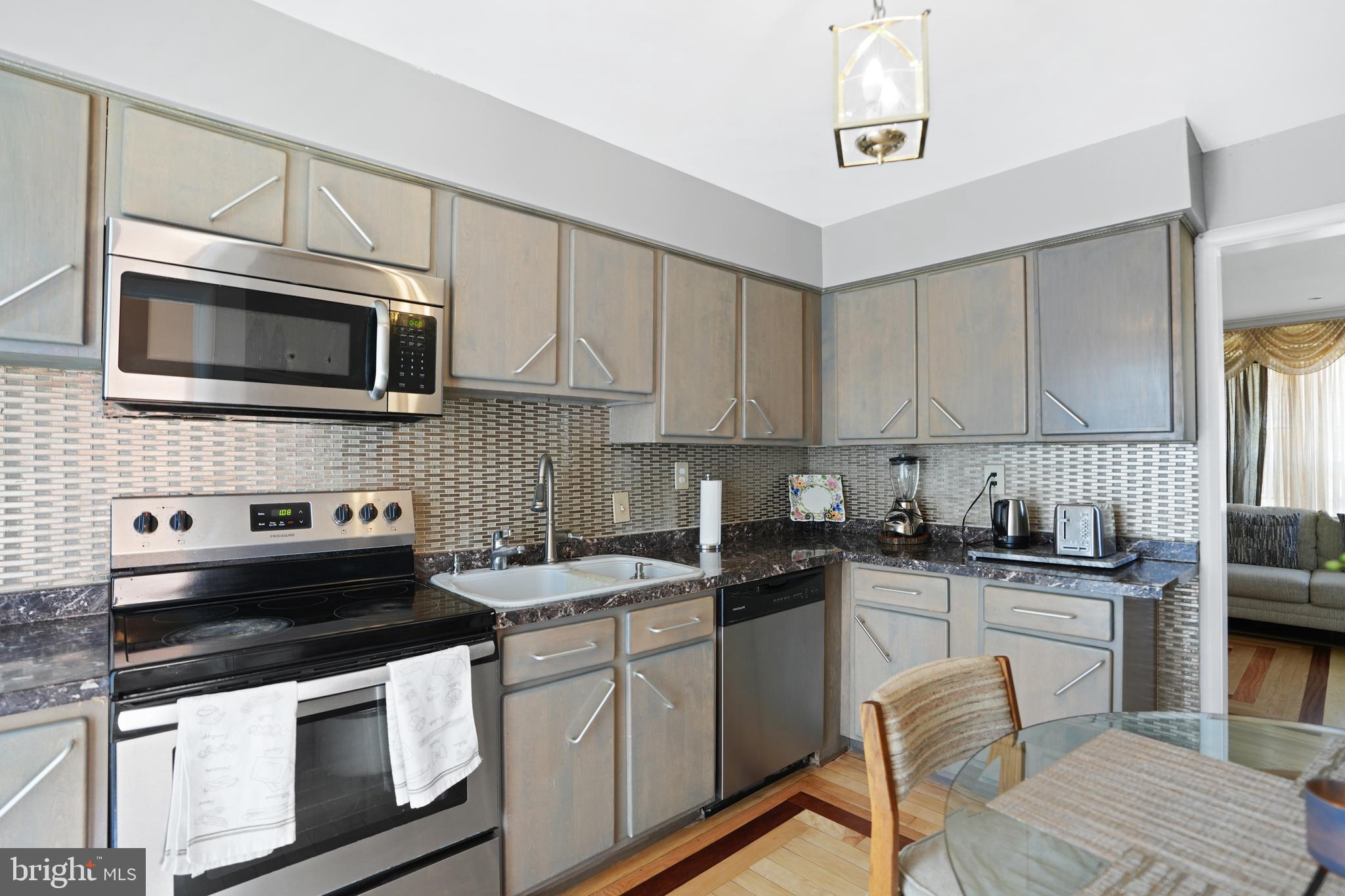 3414 Farthing Drive Silver Spring, MD 20906 - Photo 8 of 23 a kitchen with stainless steel appliances a stove a sink cabinets and a microwave