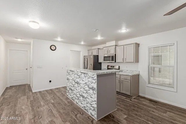 a view of kitchen with granite countertop cabinets and refrigerator