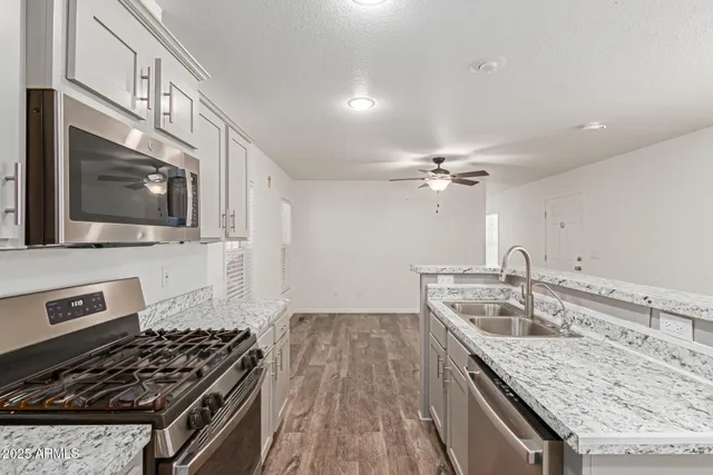 a kitchen that has a sink a microwave oven and a stove