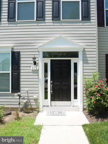 a view of a door of the house with a yard