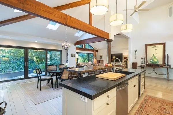 a kitchen with a stove a counter space a sink and living room view