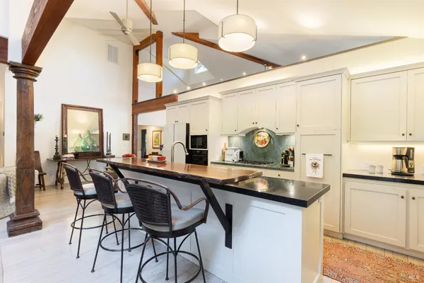 a kitchen with stainless steel appliances granite countertop a sink and chairs