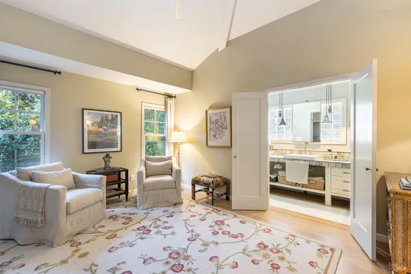 a kitchen with a sink a window and chairs