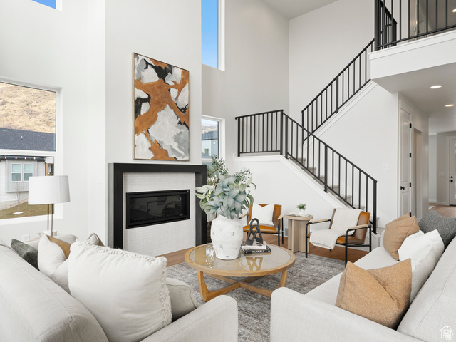 1711 West Canyon Rim Road North Lehi, UT 84048 - Photo 10 of 31 Double-height living space featuring large windows and a contemporary fireplace with a sleek black surround and white tile inlay