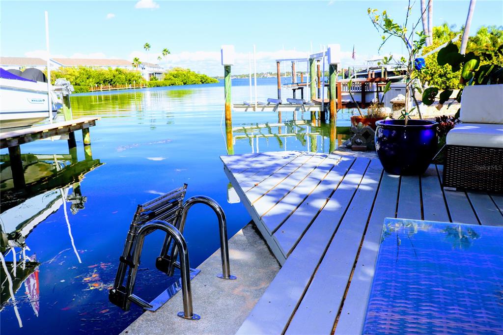 819 East Gulf Boulevard Indian Rocks Beach, FL 33785 - Photo 1 of 1 a view of a chairs and table on the wooden deck