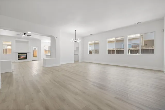 a view of empty room with wooden floor and window