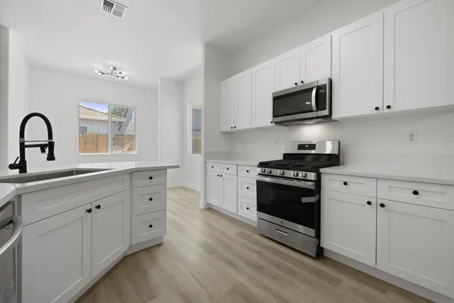 a kitchen with sink cabinets and wooden floor