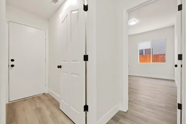 a view of an empty room with wooden floor