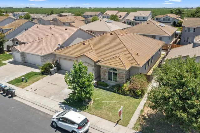 an aerial view of residential houses with outdoor space and parking