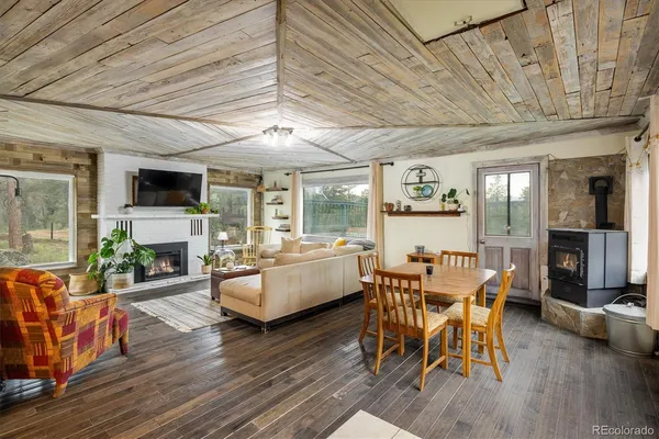 a dining room with furniture a fireplace and wooden floor