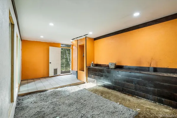 a view of a big room with an empty space and wooden floor