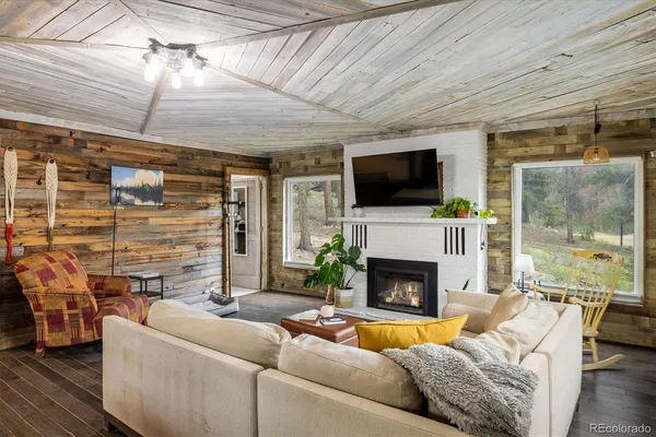 a living room with furniture a fireplace and a flat screen tv