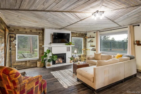 a living room with furniture a fireplace and a flat screen tv