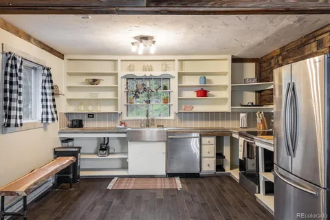a kitchen with a refrigerator and wooden floor