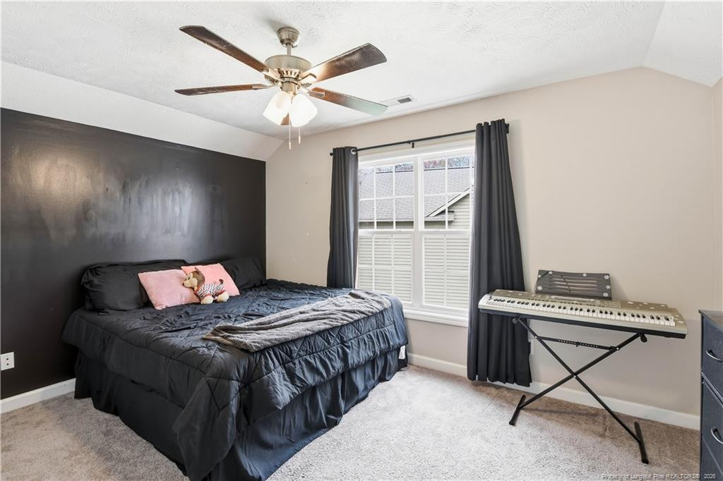 212 Lennox Loop Raeford, NC 28376 - Photo 37 of 47 a bedroom with a bed and a ceiling fan