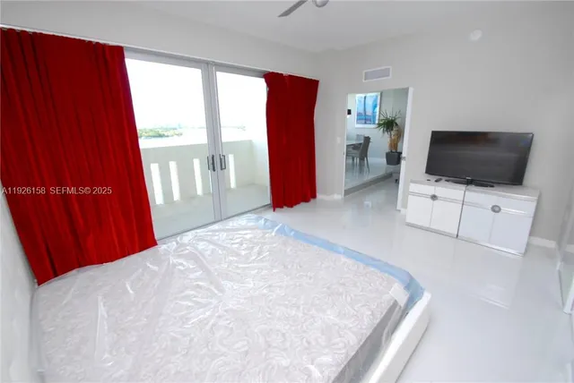 a bedroom with a bed and a flat screen tv