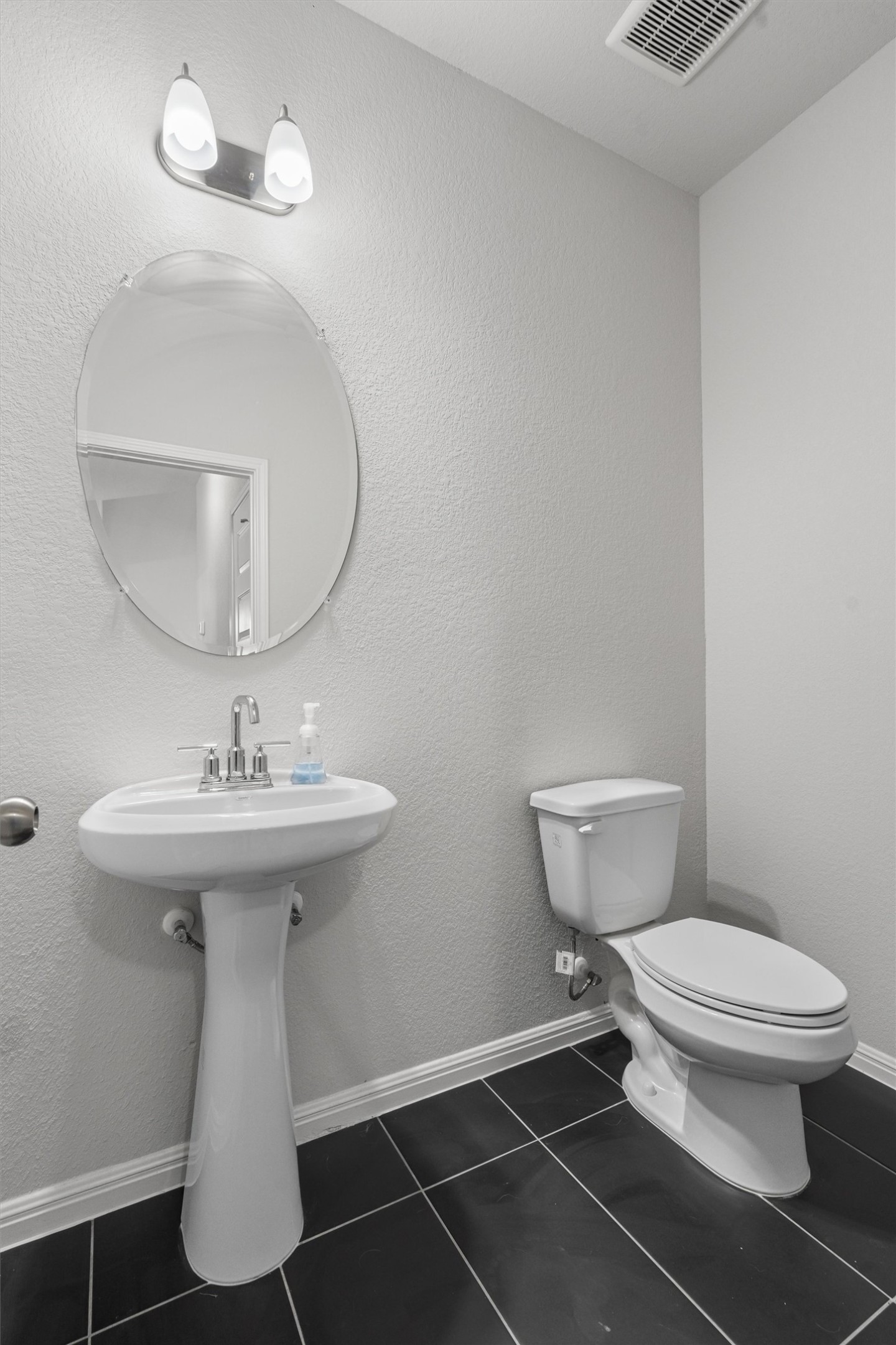 224 Backstays Loop Kyle, TX 78640 - Photo 17 of 19 Pedestal sink with chrome faucet, oval frameless mirror, and dual-bulb vanity light