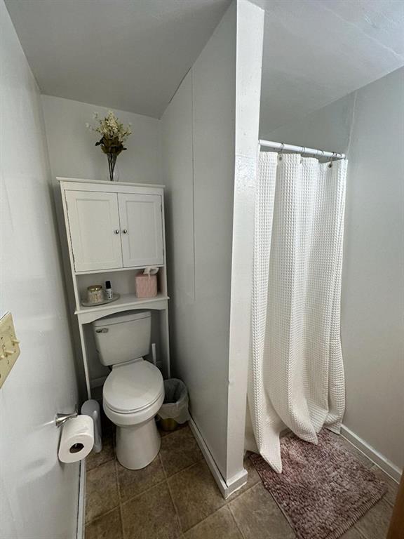 250-256 South 7th Street Indiana, PA 15701 - Photo 18 of 19 a white toilet sitting next to a shower curtain