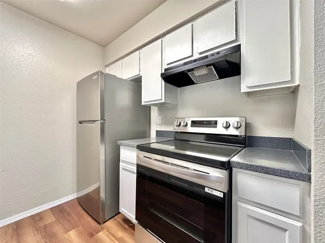 a kitchen with a sink and a wooden floor
