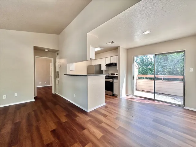 a view of a kitchen with wooden floor and electronic appliances